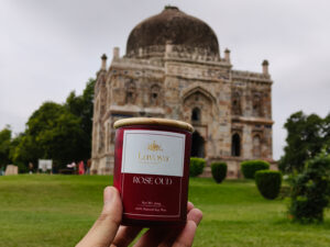 LUVOYA Rose Oud candle in a natural garden setting